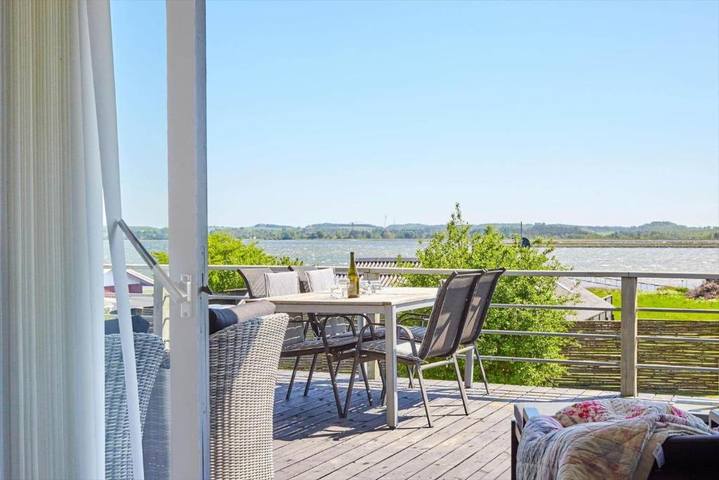 a table and chairs on a deck with a view of the water at 14249-Grevinge-Strandmosen-4 in Grevinge