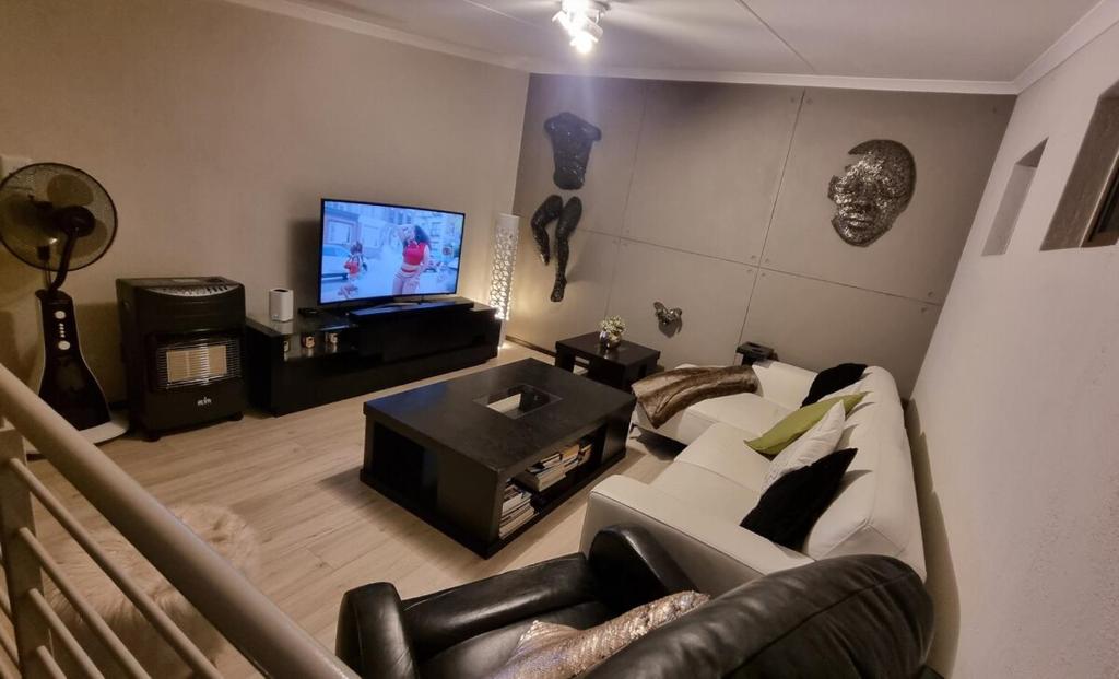 a living room with a couch and a television at 391 at SoHo in Sandton