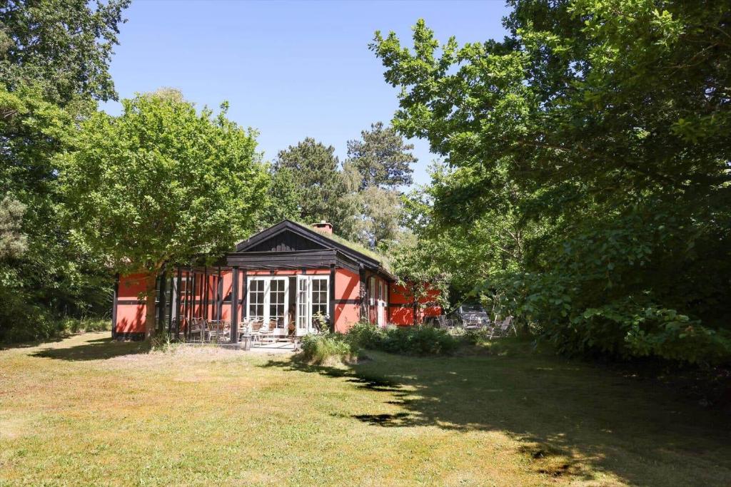 a small red house in a field with trees at 10040-Rorvig-Lyngvaenget-10 in Rørvig