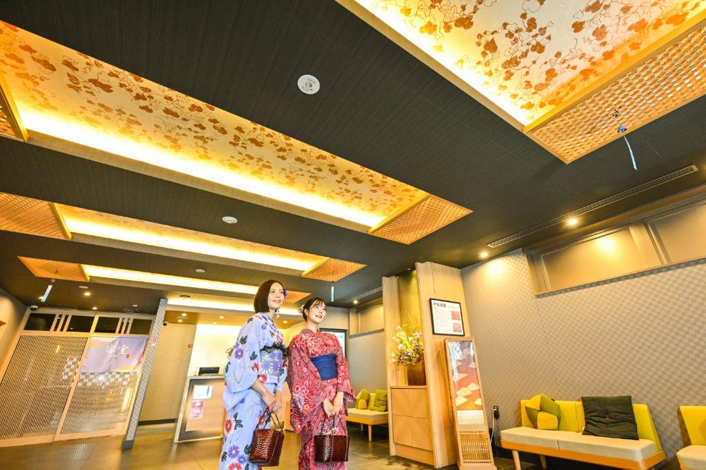 two women in kimonos standing in a lobby at Sanco Inn Kyoto Hachijoguchi Shikinoyu in Kyoto