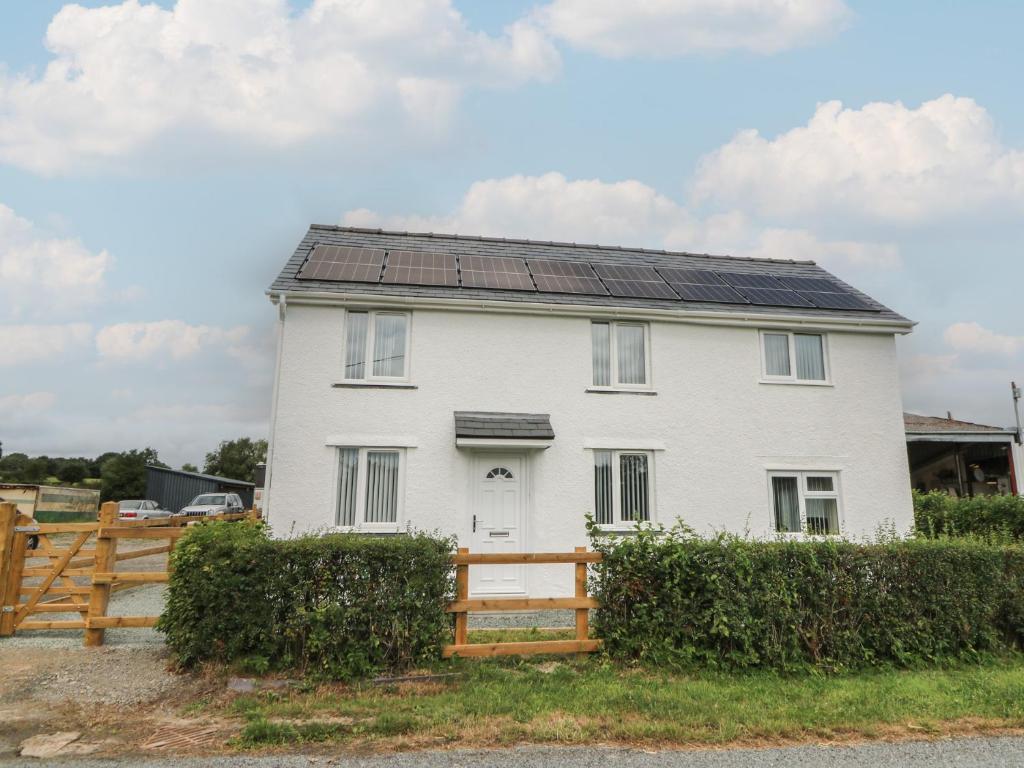 a white house with solar panels on the roof at Glandwr House in Llandrindod Wells