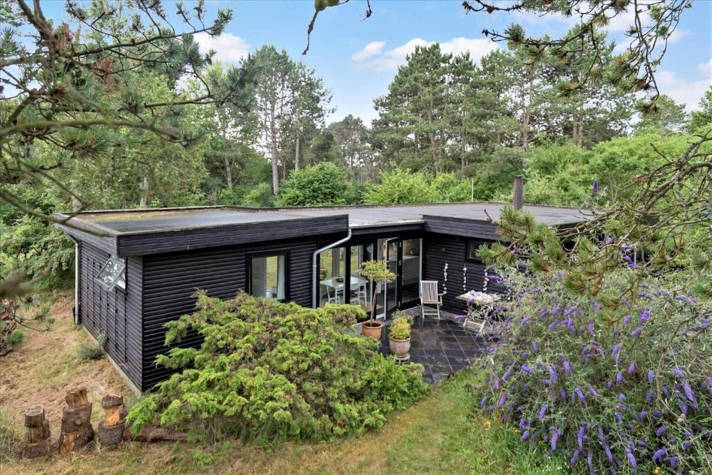 a black tiny house in the woods at 11176-Nykobing-Sj-Birkehaekken-13 in Nykøbing Sjælland