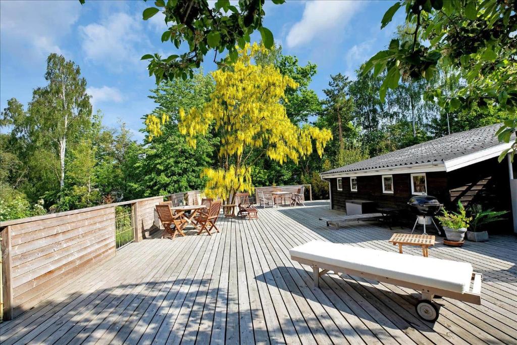 a wooden deck with a cabin and a tree at 11826-Nykobing-Sj-Lynglodden-5 in Nyrup