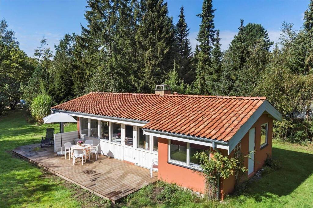 a small house with a wooden deck in a yard at 10054-Rorvig-Lindegardsvaenget-27 in Rørvig