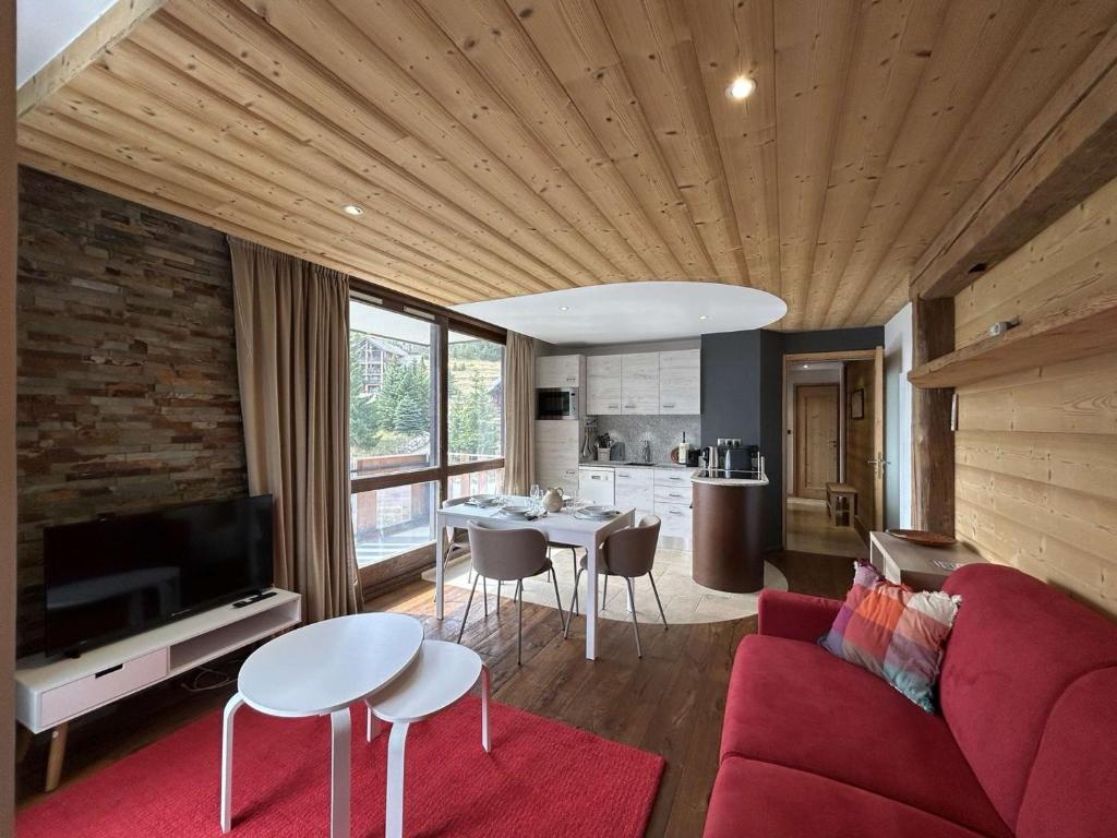 un salon avec un canapé rouge et une table dans l'établissement Appartement cosy à Montgenèvre, 4 couchages, balcon, Wi-Fi, parking - FR-1-330D-145, à Montgenèvre