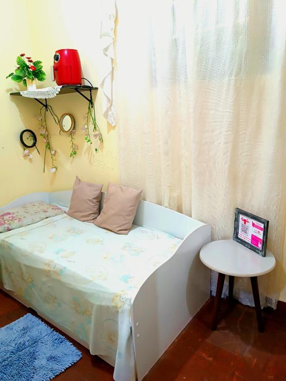 ein kleines Bett mit einem Tisch und einem Laptop darauf in der Unterkunft Pequenino in Sao Jose do Rio Preto