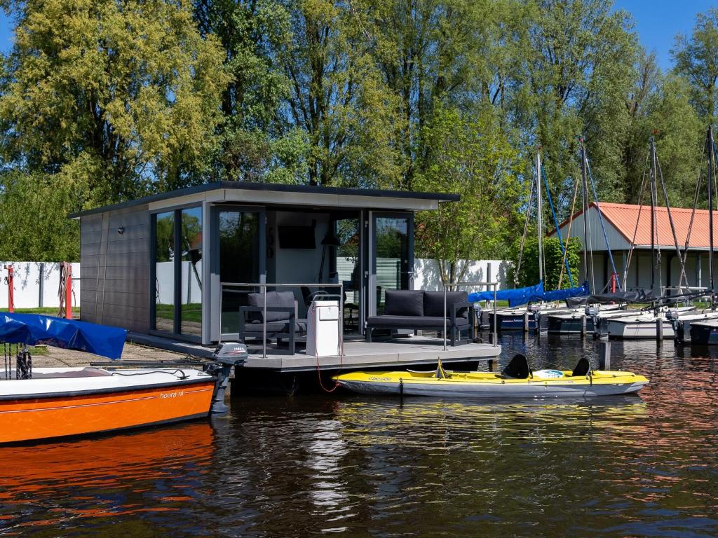 ヘーグにあるHouseboat in Heeg with Stunning Marina Viewsの水上に2隻のボートがある桟橋の上の小屋