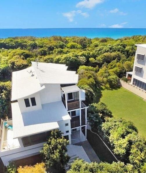 an aerial view of a white house with the ocean at Beachside House in Sebel Resort in Twin Waters