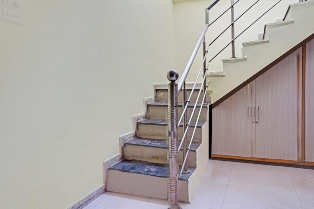 Una escalera en una casa con puerta de madera en Hotel O The Buddha Residency, en Dānāpur