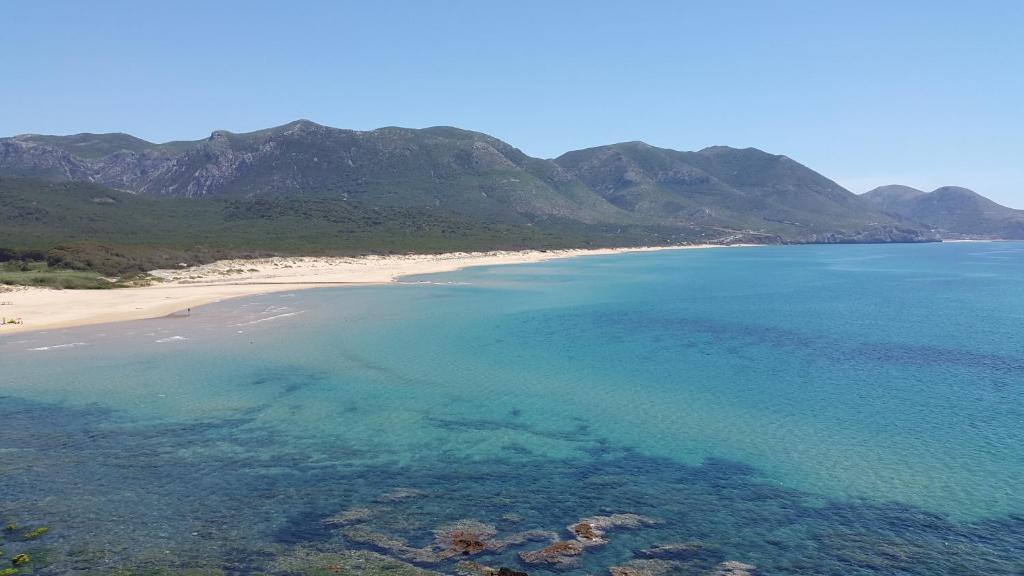 an aerial view of a beach with mountains in the background at Villa l'orto Portixeddu Sardegna in Fluminimaggiore