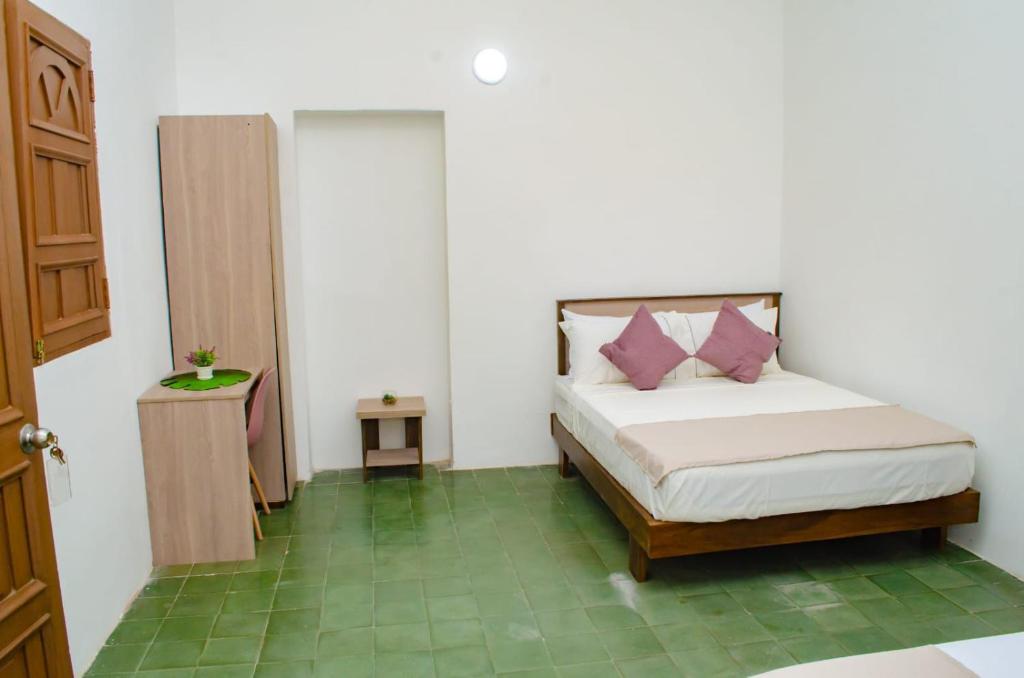 une chambre avec un lit avec des oreillers roses dessus dans l'établissement Puertas de la Bahía, à Santa Marta