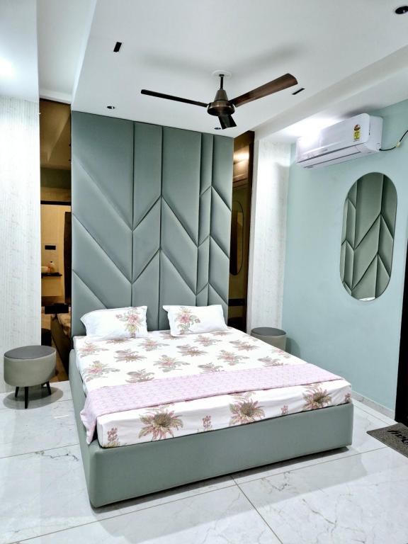 Un dormitorio con una cama y una pared azul. en Mahadev Home stay, en Ujjain