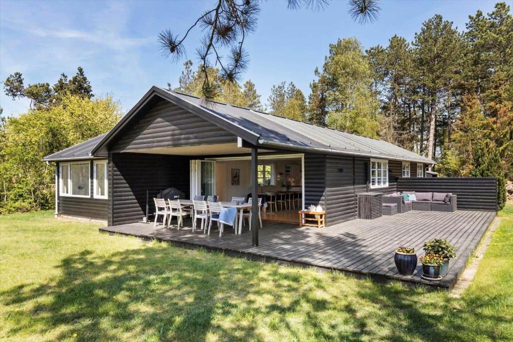 克内贝尔8210-Knebel-Kamillevej-16的一间黑色小屋，带有带桌子的甲板