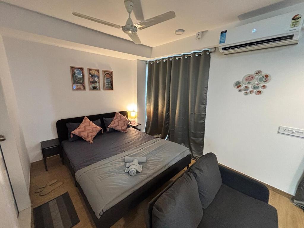Un dormitorio pequeño con una cama y un sofá. en Vibrant Vision Near Airport with Coffee Maker & Wifi, en Pune