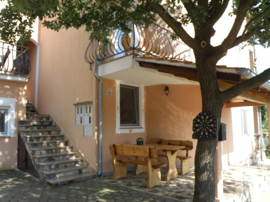 ein Haus mit einem Tisch und einer Bank neben einem Baum in der Unterkunft Apartment Akaju in Rovinjsko Selo