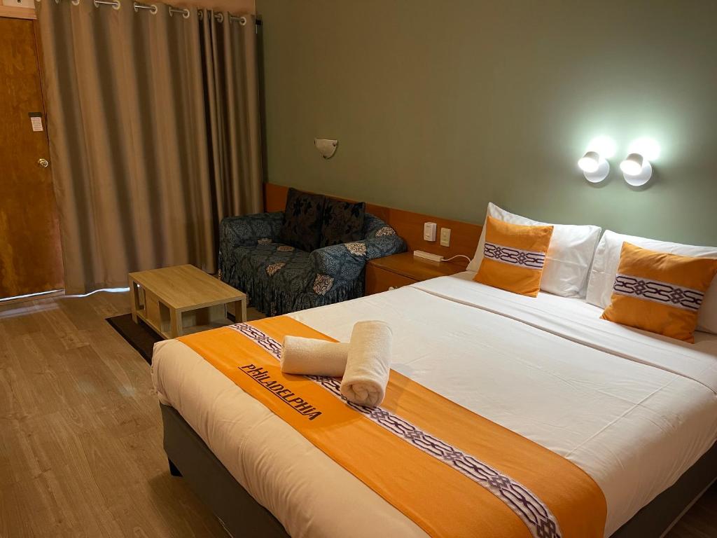 a hotel room with a bed and a chair at Philadelphia Motor Inn in Echuca