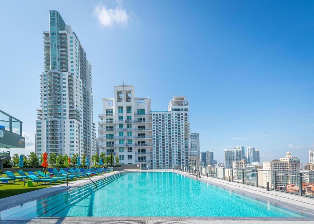 a large swimming pool on top of a building with tall buildings at High-Rise Luxury Condo in Downtown Miami in Miami