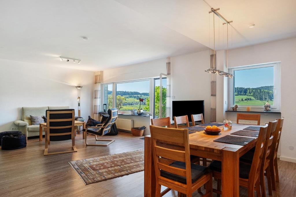 a dining room and living room with a table and chairs at Ferienhaus Kiliani in Bernau im Schwarzwald