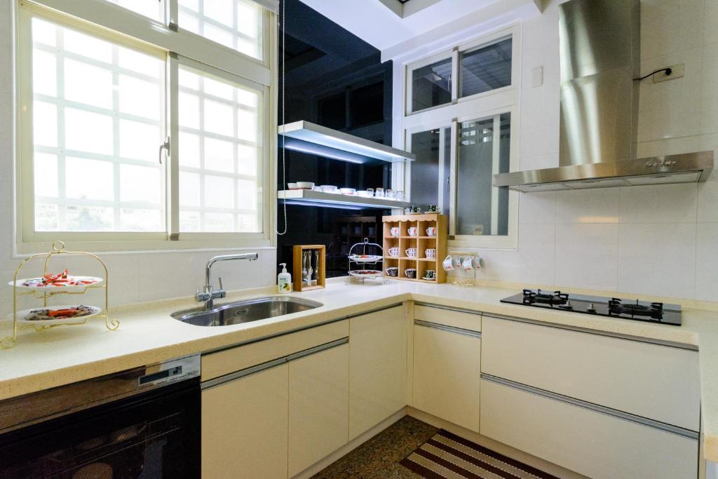 a kitchen with white cabinets and a sink at Hualien Macaron B&amp;B in Ji&#39;an