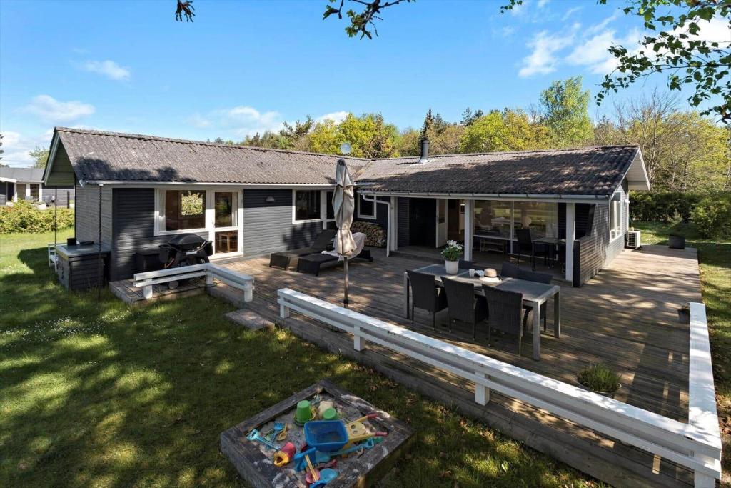a house with a wooden deck in the yard at 8007-Knebel-Soren-Jeppesens-Vej-5 in Knebel