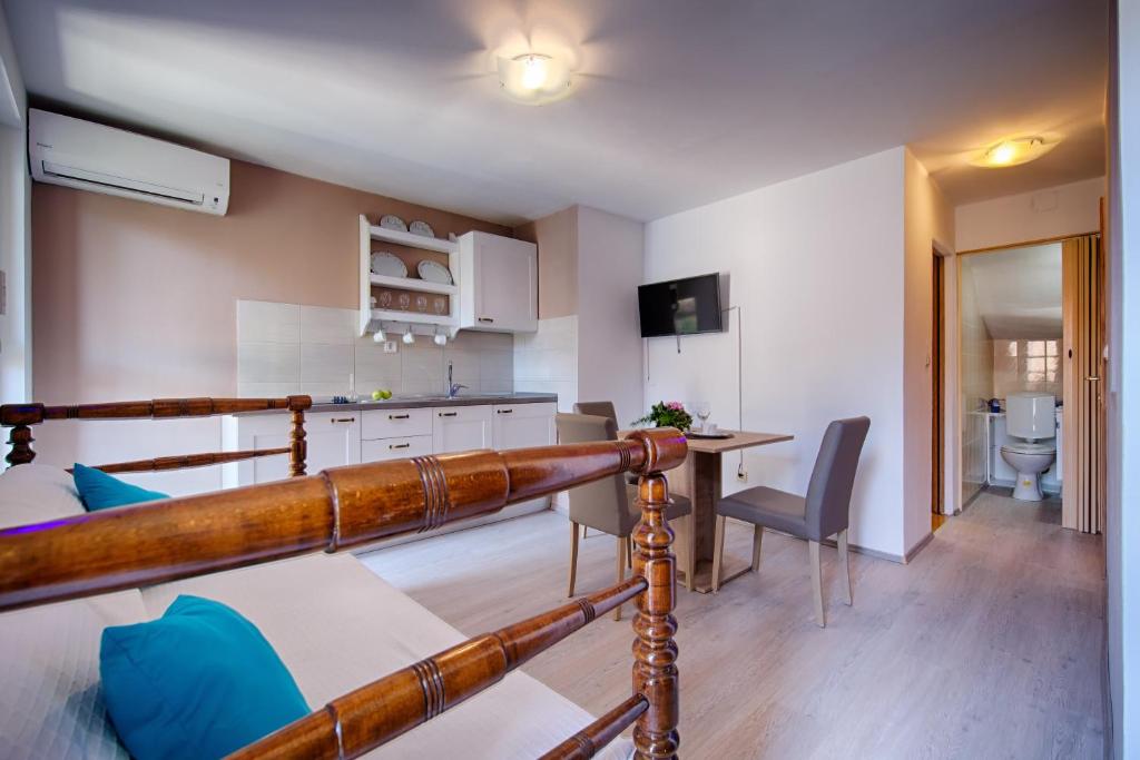 a kitchen and a living room with a bed and a table at Apartments Villa Anka in Komiža