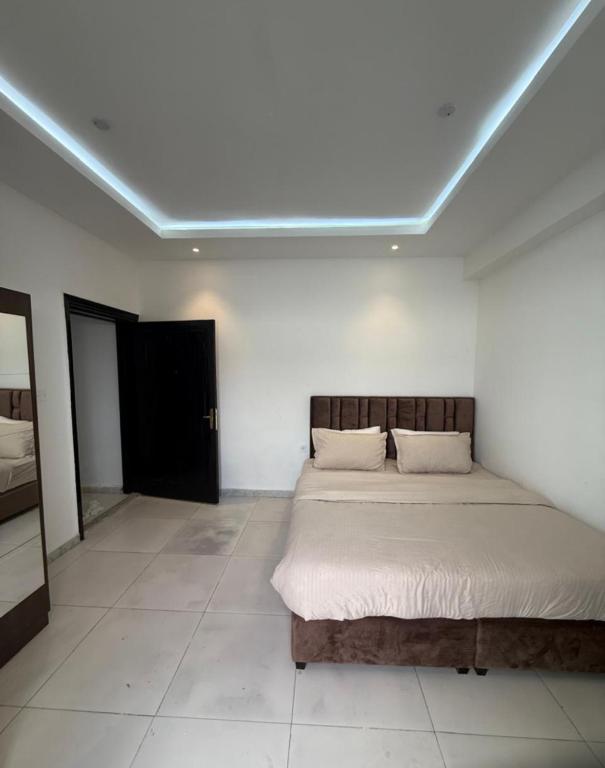 a bedroom with a bed in a white room at New Manaser apartment in Al Ain