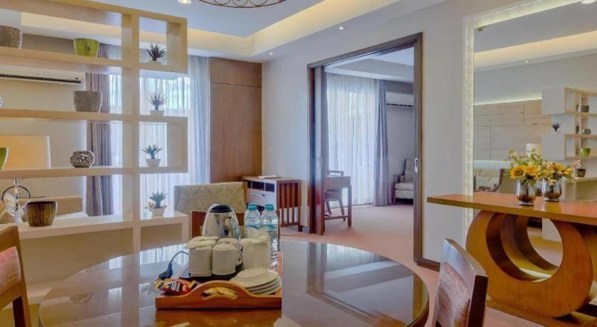 a living room with a glass table and a dining room at Mansion Garden Hotel in Olongapo