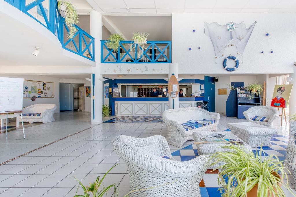 a lobby with blue and white chairs and a counter at Hôtel L&#39;Océane in Andernos-les-Bains