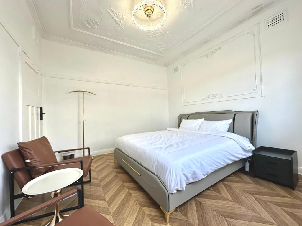 una camera da letto con un letto, un tavolo e una sedia di Modern Vintage King and Single Rooms a Bankstown