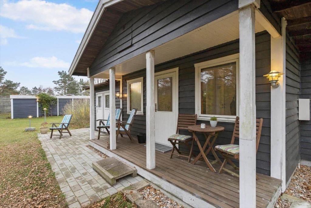 a porch of a house with a table and chairs at 84230-Ebeltoft-Skovduevej-10 in Ebeltoft