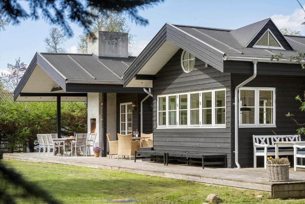 a black house with a porch and a patio at 8242-Knebel-Uraniavej-5 in Knebel