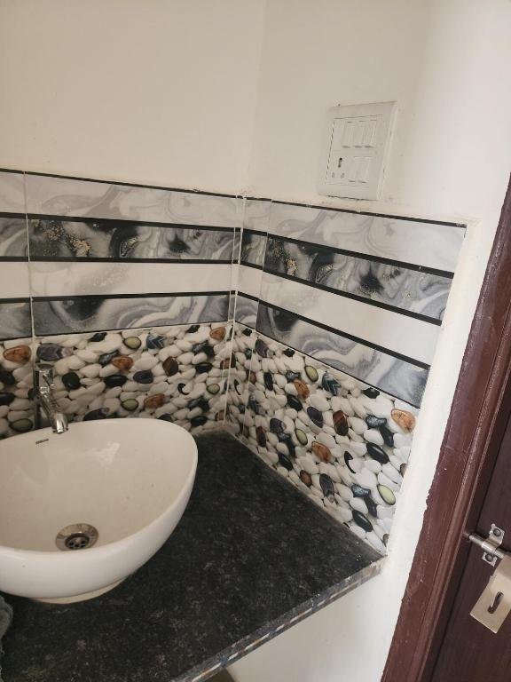 een badkamer met een wastafel en een toilet en stenen aan de muur bij apartment in Jabalpur 