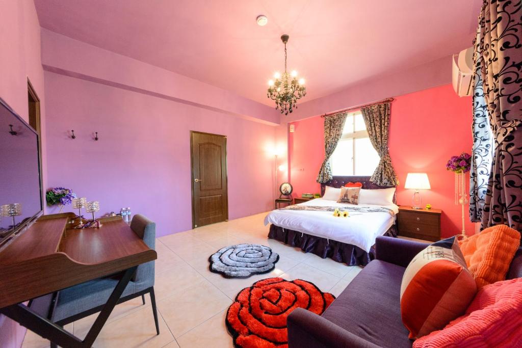 a bedroom with pink walls and a bed and a desk at Hualien Macaron B&amp;B in Ji&#39;an