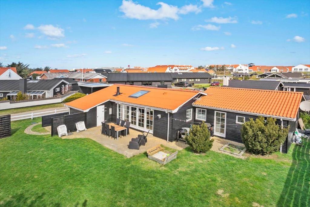 BL856-Blokhus-Soren-Tjenersvej-2 في بلوكهوس: اطلالة علوية على منزل بسقف برتقالي