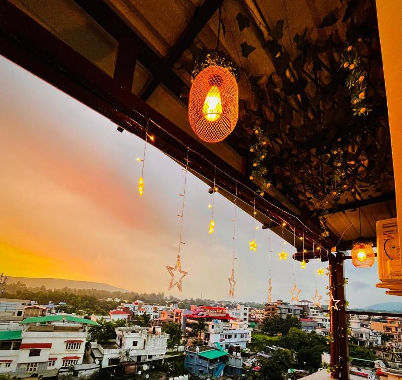 een uitzicht op een stad bij zonsondergang vanuit een restaurant bij The Scenic Roofhouse by Amrove near Rajpur road in Dehradun