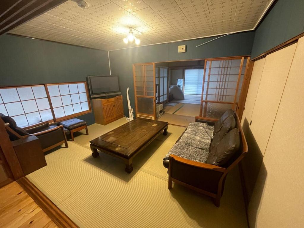 una sala de estar con un sofá y una mesa en キッチンが使いやすい田舎の一棟貸, en Yamaguchi