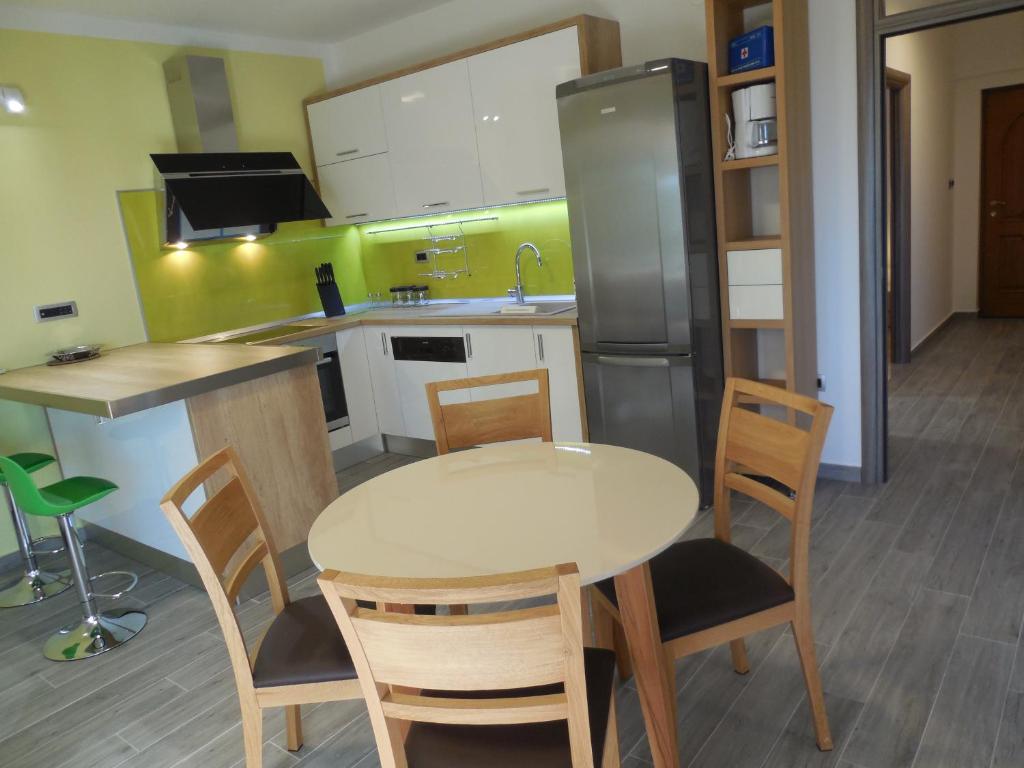 a kitchen with a table and chairs and a refrigerator at Apartments Jukic in Klis