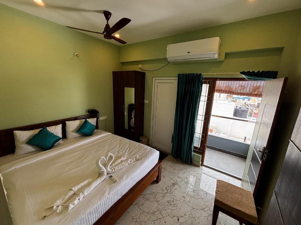 Schlafzimmer mit einem Bett, einem Ventilator und einem Fenster in der Unterkunft Maison Sakee near Rock Beach White Town in Puducherry