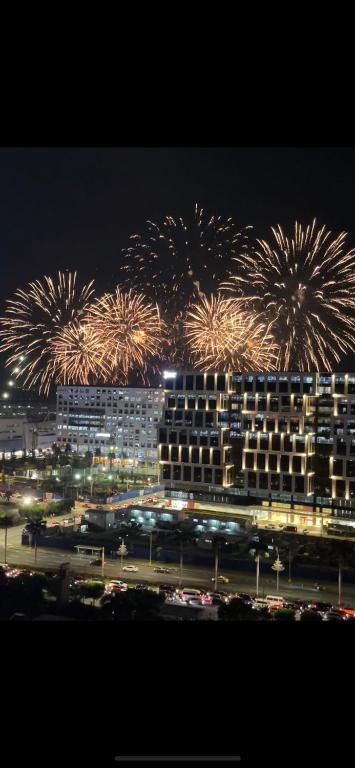a fireworks display over a large building with cars at Affordable staycation at SHORE RESIDENCES Near MOA and NAIA in Manila