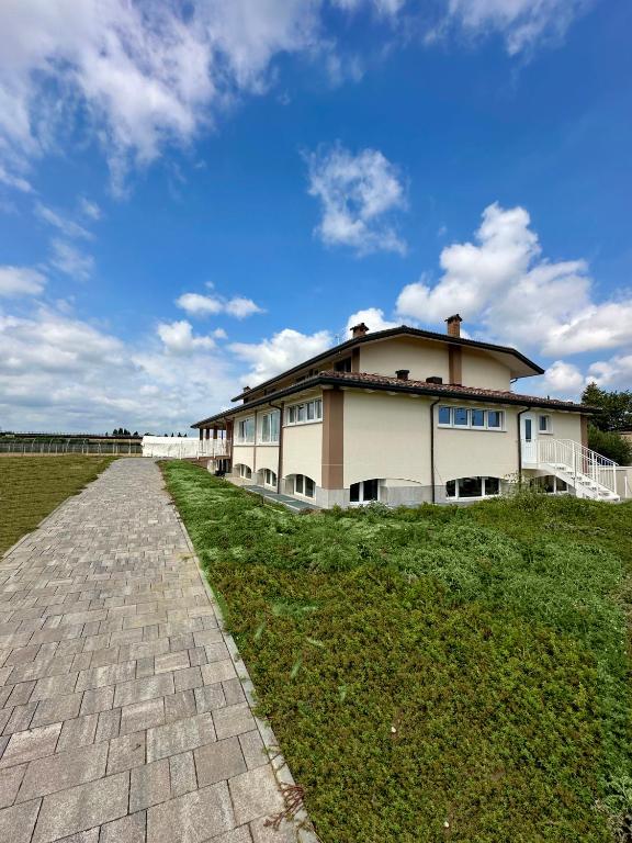 a large house on a field with a brick road at AgriResort Il Casolare Rimini in Rimini