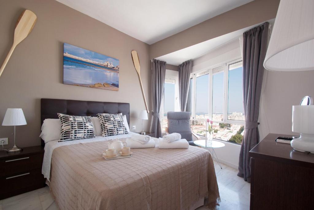 - une chambre avec un lit et une grande fenêtre dans l'établissement Apartment Altavista, à Cadix