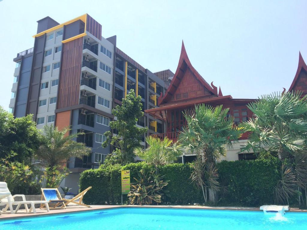 a hotel with a swimming pool in front of a building at Huahin Terminal in Hua Hin