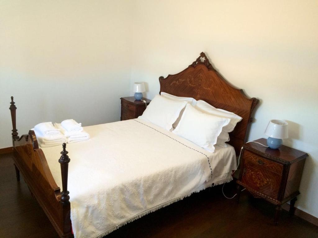 1 dormitorio con 1 cama con sábanas blancas y 2 mesitas de noche en Private Room in Old Town, en Viana do Castelo