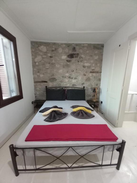 a bedroom with a large bed with a red blanket at Με θέα το Αιγαίο in Agia Marina Lesvos