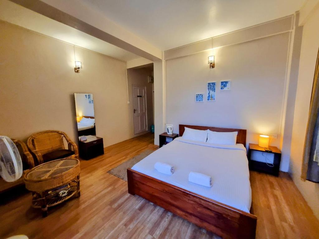 a bedroom with a large bed and a chair at Breeze Vale Homestay in Shillong