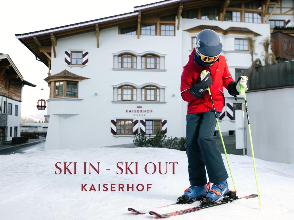a person on skis in the snow in front of a building at Hotel Kaiserhof Kitzbühel, 4 Sterne Superior in Kitzbühel