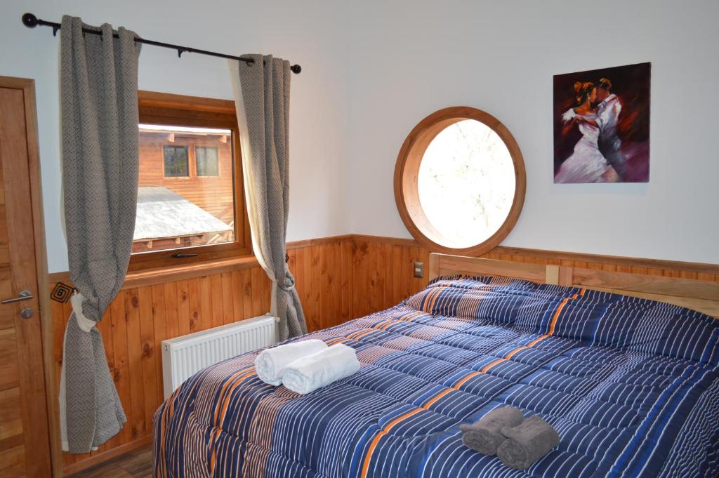 Schlafzimmer mit einem Bett und einem Fenster in der Unterkunft HOTEL & HOSTAL CHIL'IN, Las Trancas in Las Trancas