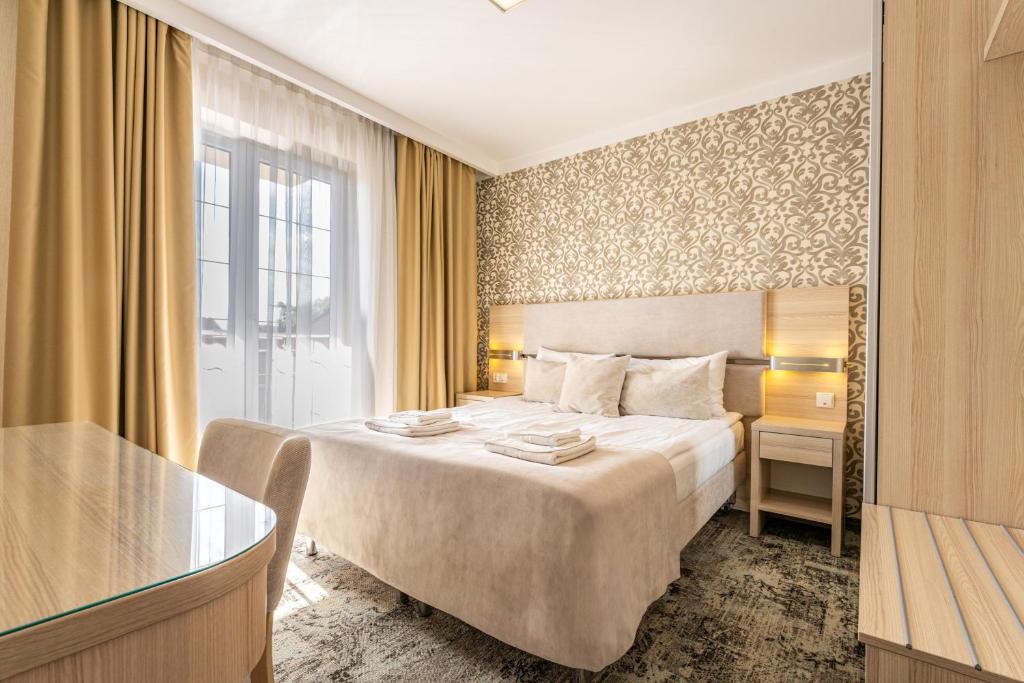 a hotel room with a large bed and a window at Villa Cannes Jastarnia in Jastarnia