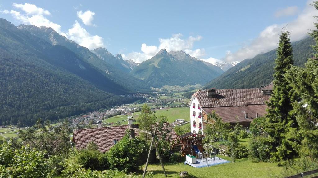 a house in a valley with mountains in the background at Landhaus Birgit in Telfes im Stubai