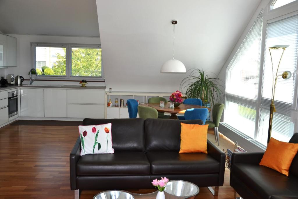 een woonkamer met een zwarte bank en een tafel bij Ferienwohnung Am Bergle in Überlingen